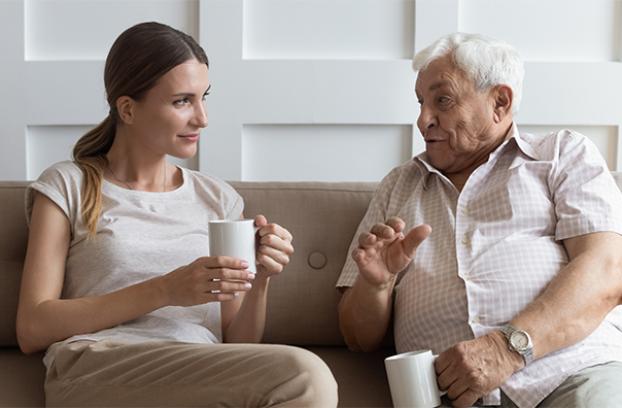 Women and man with mugs in conversation